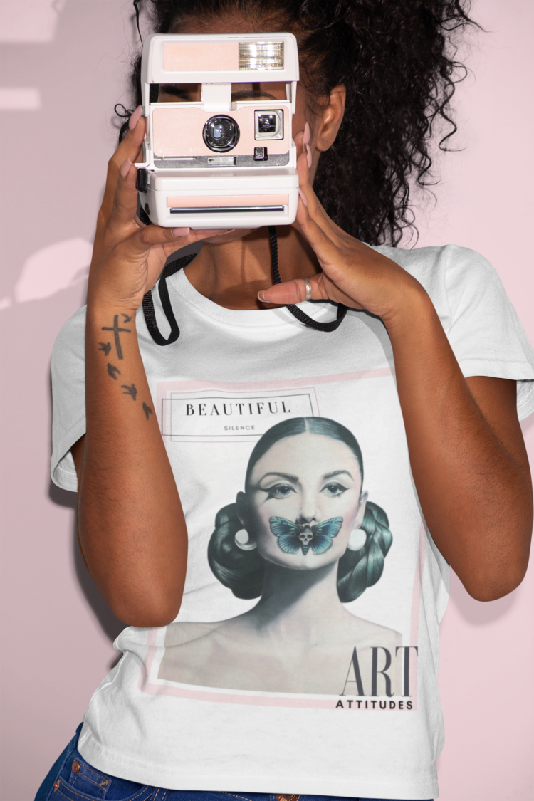 Woman with a polaroid camera wearing a white t-shit with a motive of a woman with a butterfly over her mouth