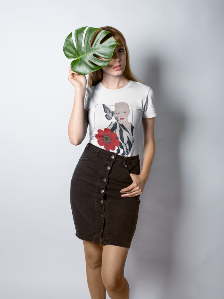 woman holding a leaf wearing a black skirt and a white t-shirt with a motive of a woman in a balck and white striped shirt and a big red flower on her right side and a big butterfly next to her head