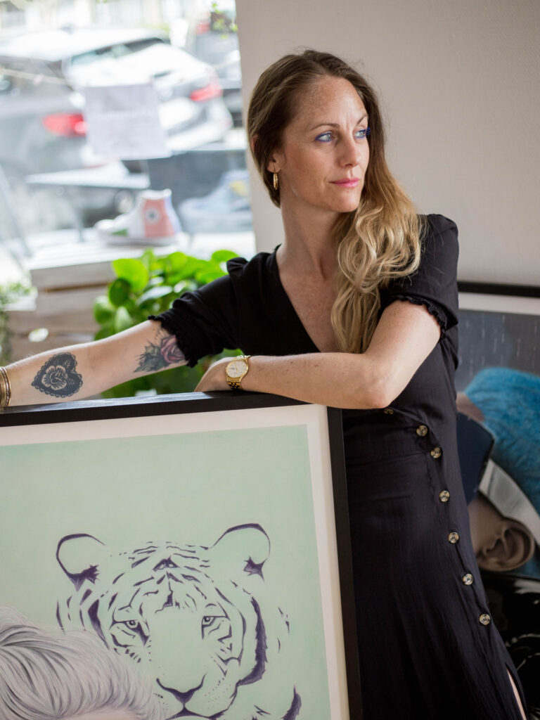 Christine Petersen in a black dress standing next to a big drawing