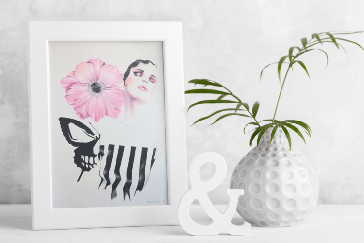 Pastel drawing of a woman in a black and white striped shirt looking up with a pink flower next to her head and a skull butterfly behind her back in a small white frame next to a plant
