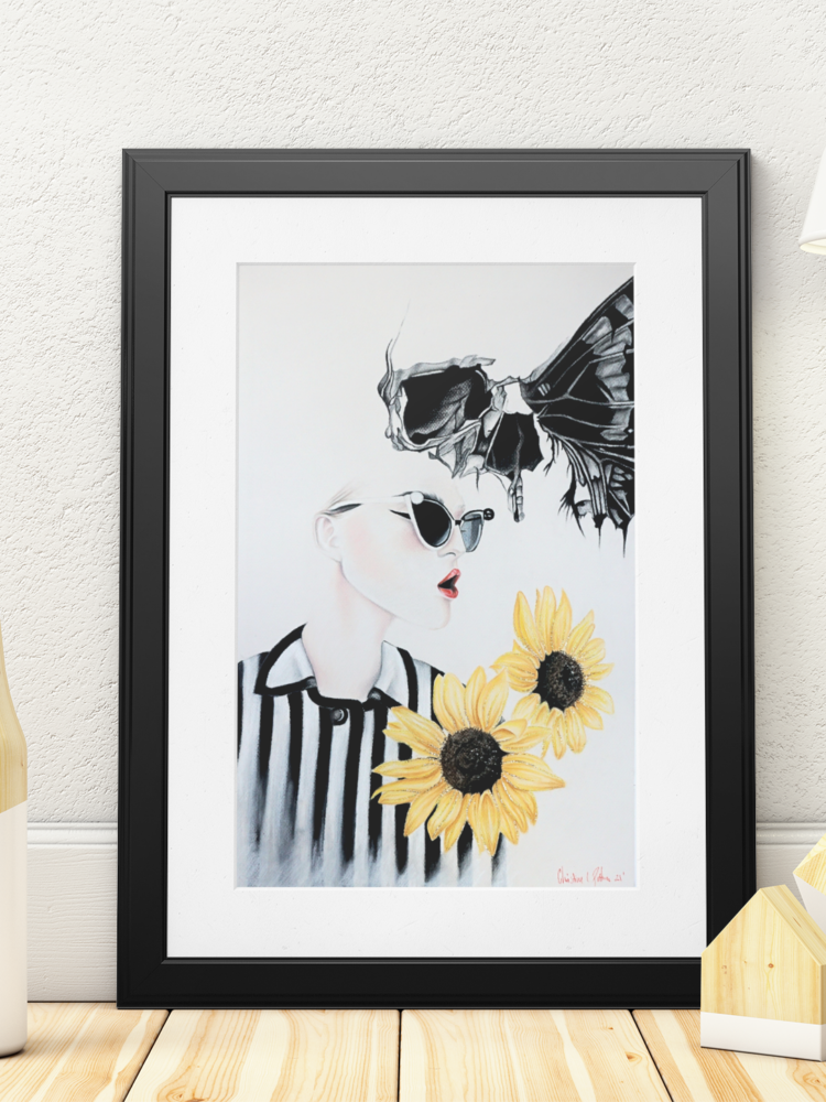 Pastel drawing of a woman in a black and white shirt with two sunflowers in the right coner and a skull butterfly next to her head in a black frame standing on a table next to a white lamp
