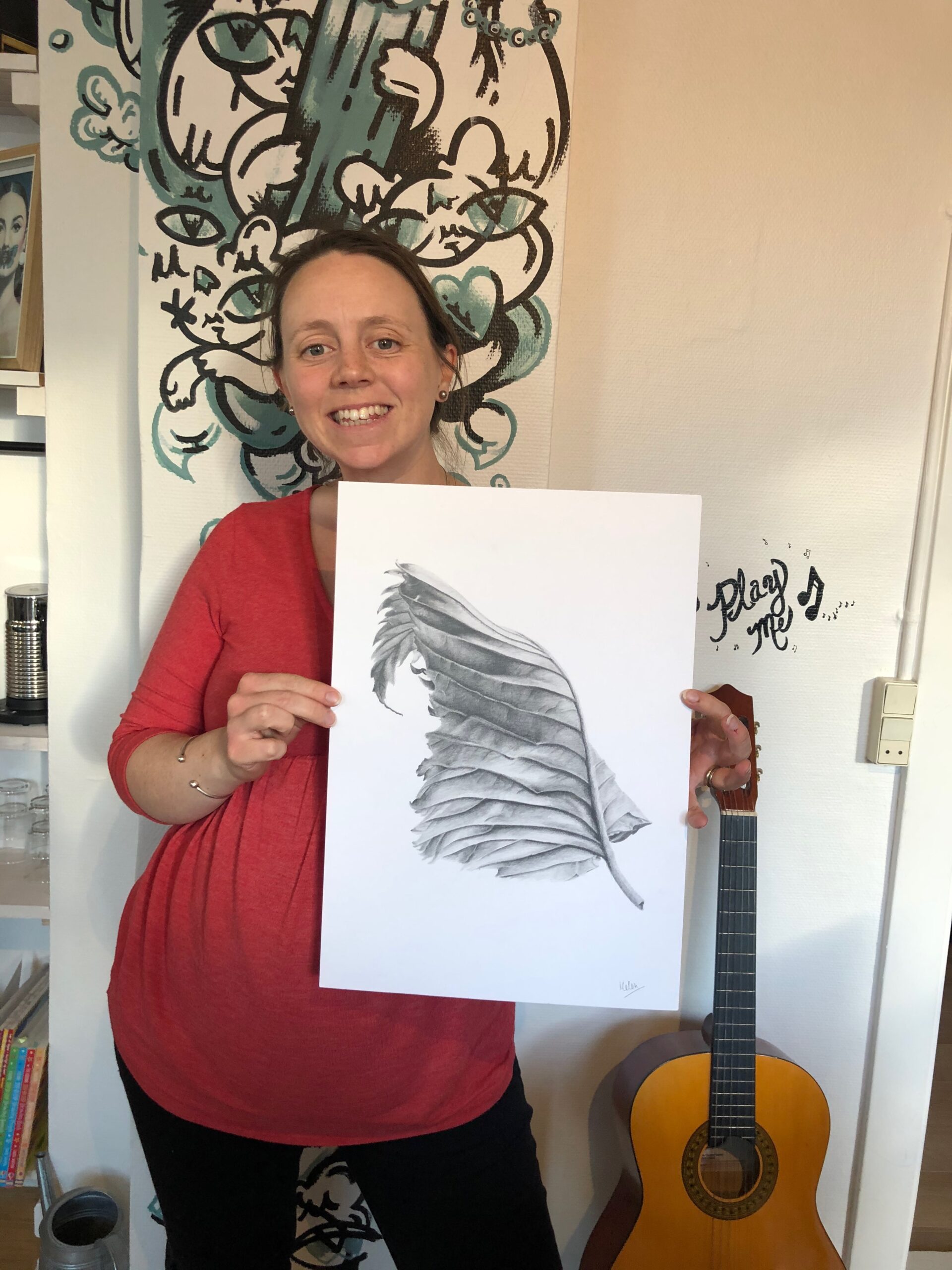 Picture of drawing student holding her drawing of a leaf