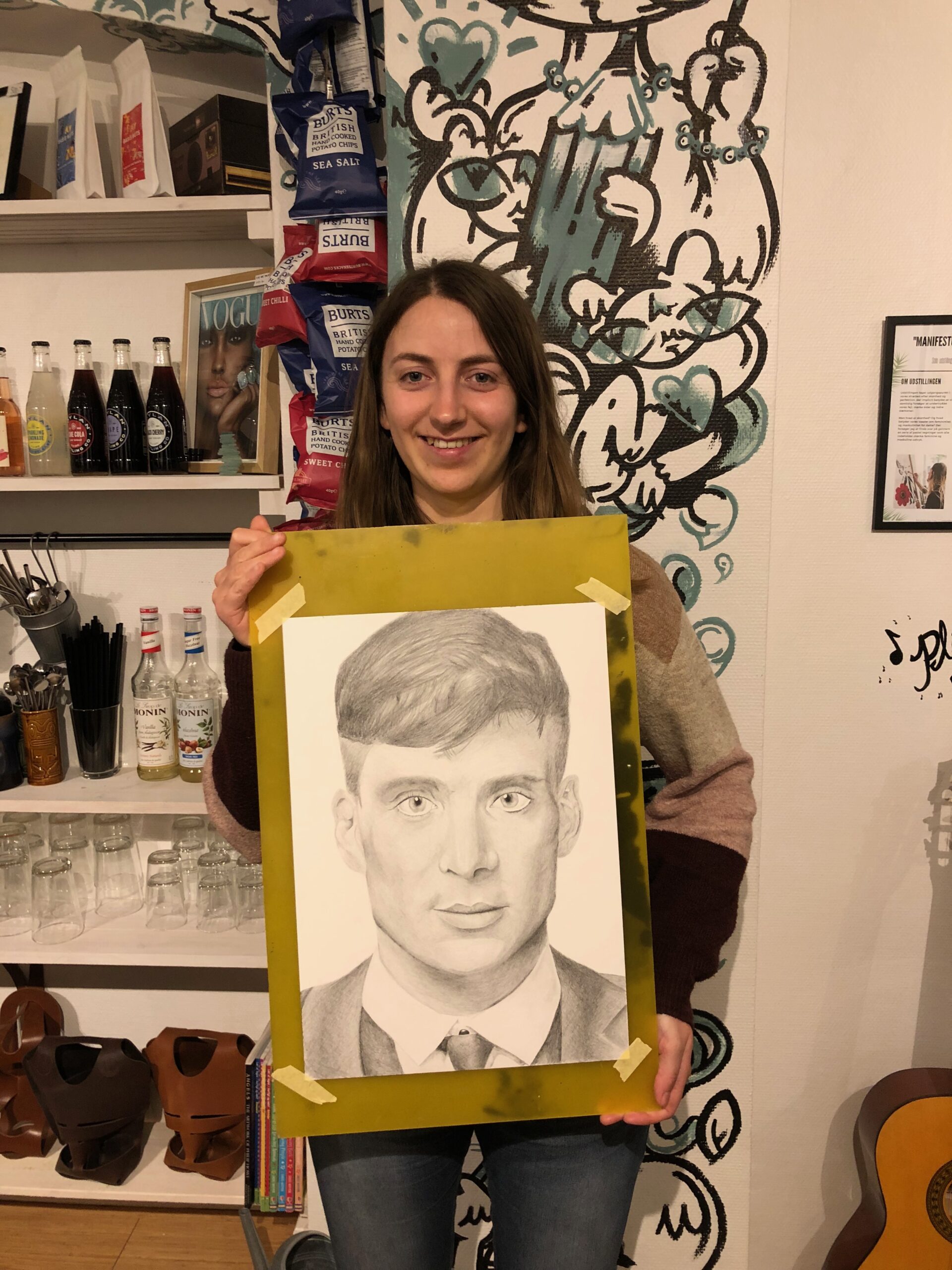 Picture of drawing student holding her drawing of Cillian Murphy